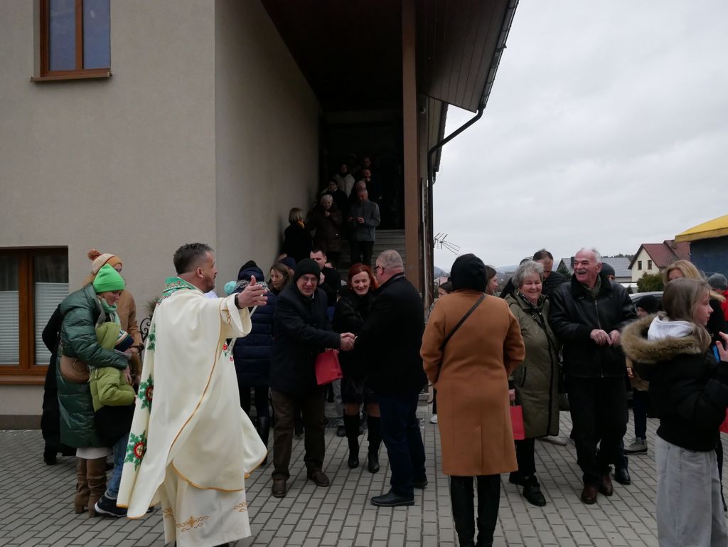 Ksiądz i parafianie na placu